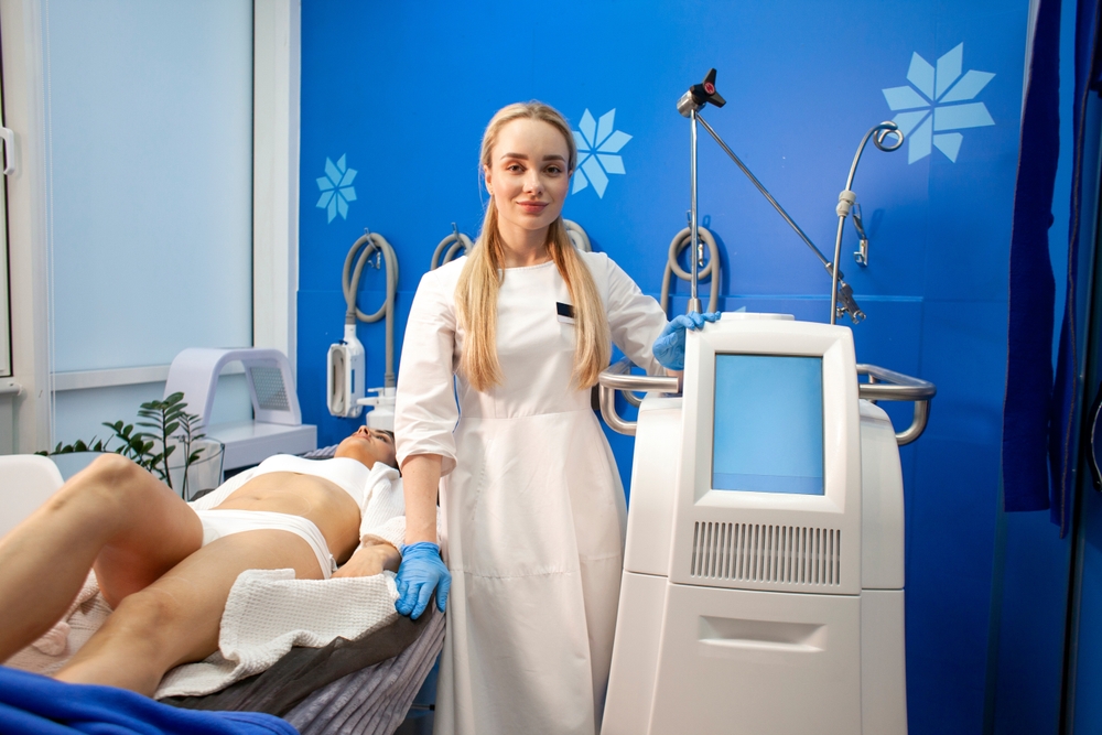Coolsculpting Expert treating a woman laying on medical bed freezing fat